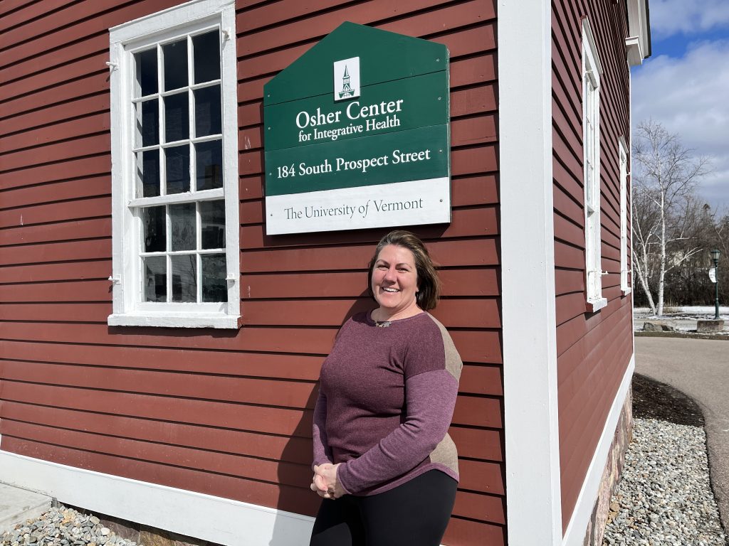 A person standing outdoors next to a red and white building